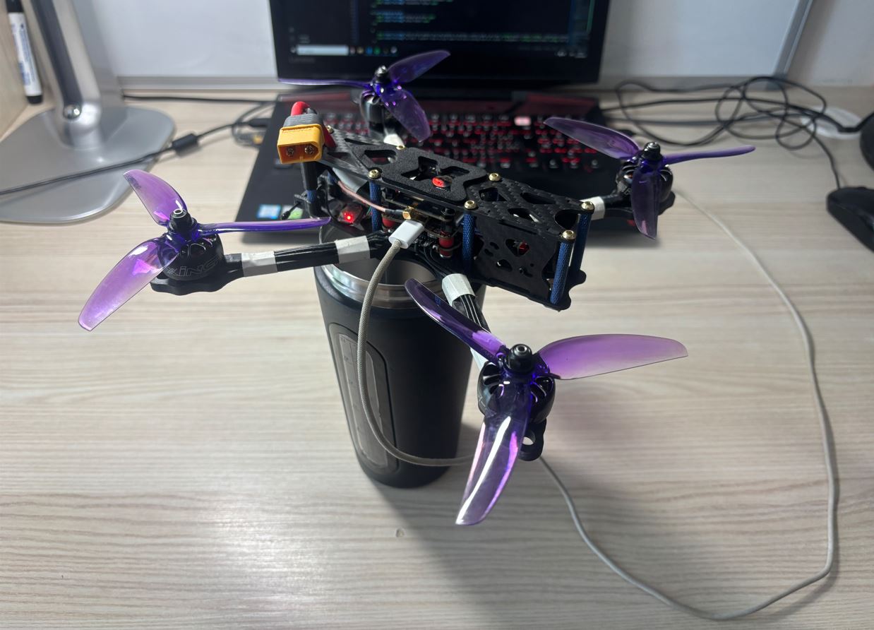 Dron položený na termosce při kalibraci akcelerometru. / Drone resting on a thermos during accelerometer calibration.